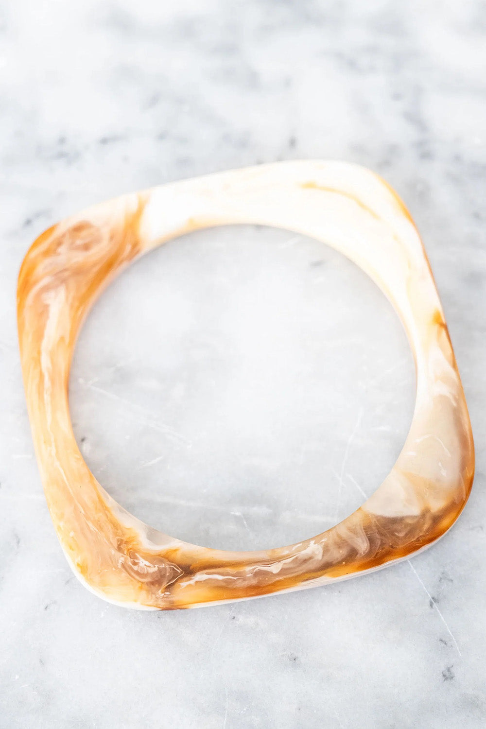 A model wearing the Square Resin Stacking Bangle in colour Horn, from the front, showing the whole outfit