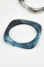 A model wearing the Square Resin Stacking Bangle in colour Navy (Blue), from the front, showing the whole outfit