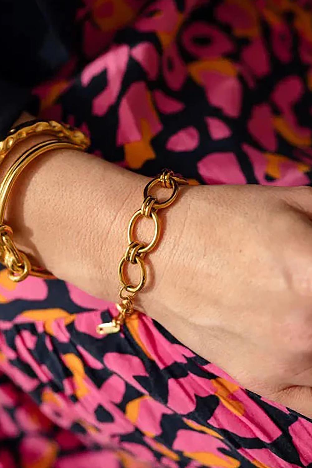 A model wearing the Sybil Gold Link Bracelet in colour Gold (Metallics), from the front, cropped image