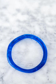 A model wearing the Wave Resin Stacking Bangle in colour Cobalt (Blue), from the front, showing the whole outfit