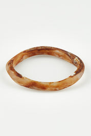 A model wearing the Wave Resin Stacking Bangle in colour Horn, from the front, showing the whole outfit