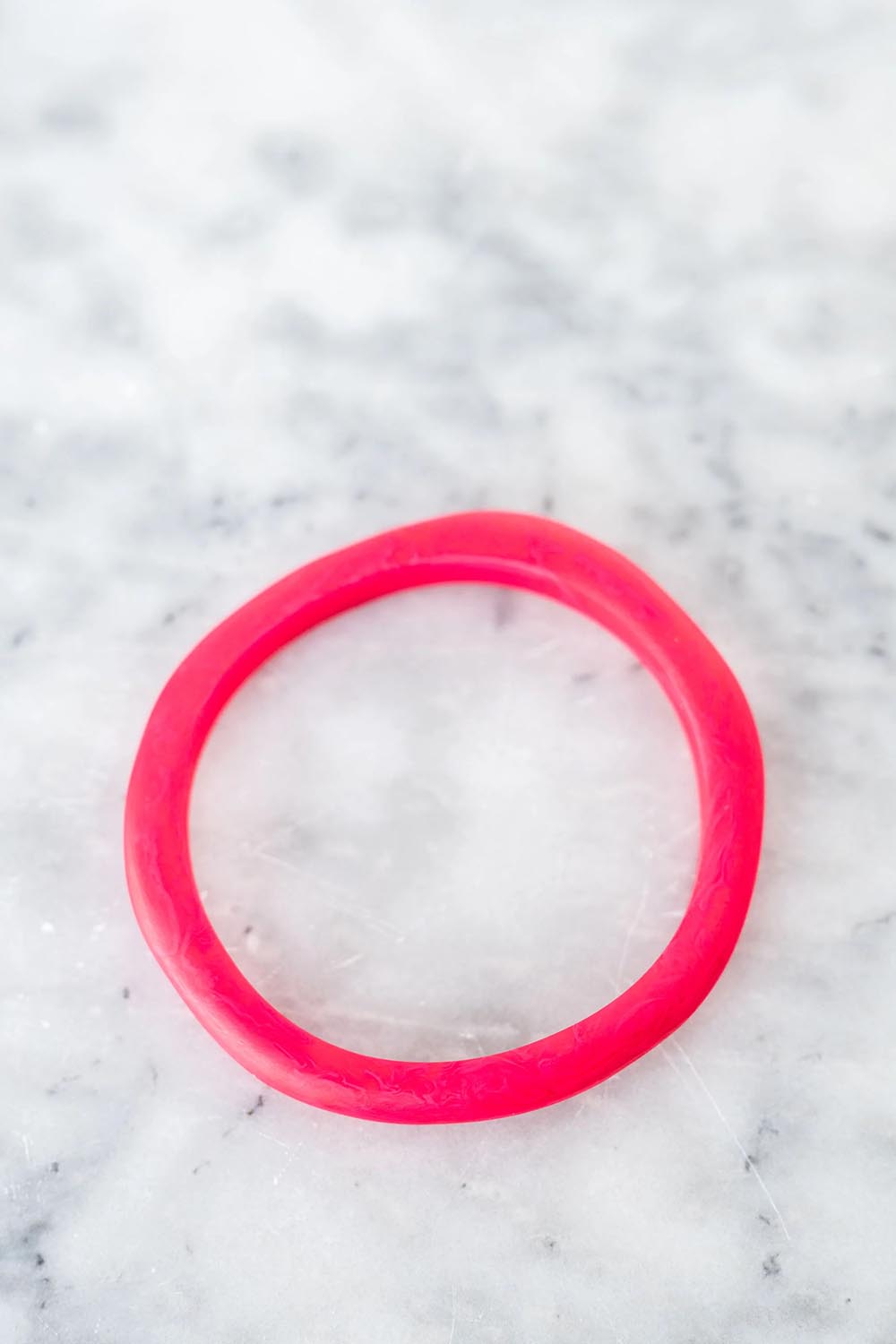 A model wearing the Wave Resin Stacking Bangle in colour Hotpink (Pink), from the front, showing the whole outfit