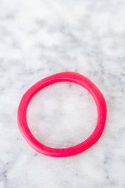 A model wearing the Wave Resin Stacking Bangle in colour Hotpink (Pink), from the front, showing the whole outfit