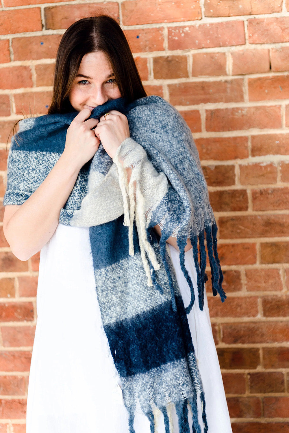 A model wearing the Charlie Checker Scarf in colour Navycream (Blue), from the front, showing the whole outfit