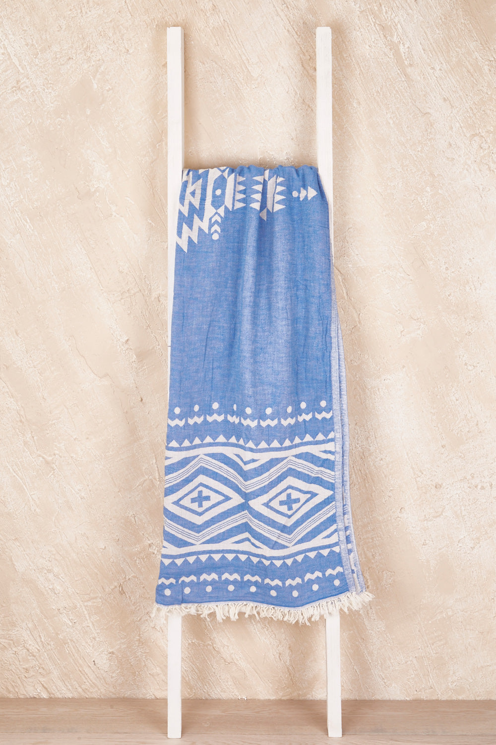 A model wearing the Hammamas Aztec Cotton Towel in colour AztecBlue (Blue), from the front, showing the whole outfit