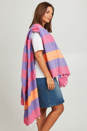Model Monique wearing size OneSize of the Hammamas Clash Towel in colour Candyiris (Pink), from the front, cropped image