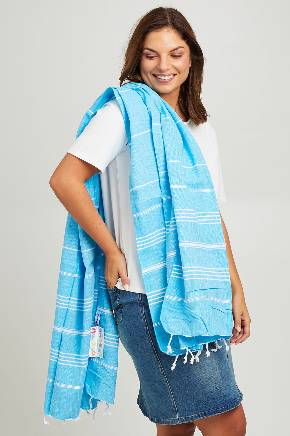 Model Monique wearing the Hammamas Original Cotton Towel in colour Aqua (Blue), from the front, cropped image