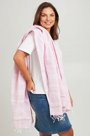 Model Monique wearing the Hammamas Original Cotton Towel in colour Rose (Pink), from the front, cropped image