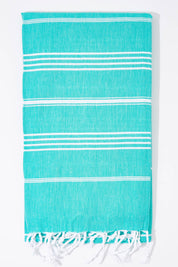 A model wearing the Hammamas Original Cotton Towel in colour Spearmint (Green), from the front, showing the whole outfit
