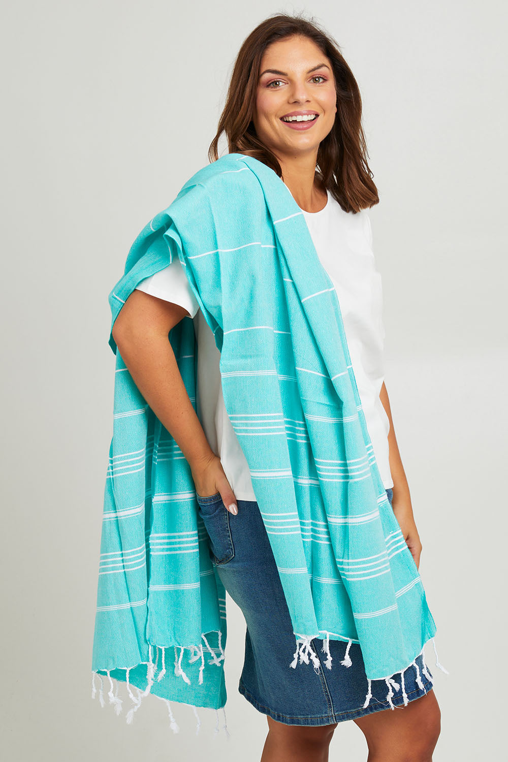Model Monique wearing the Hammamas Original Cotton Towel in colour Spearmint (Green), from the front, cropped image