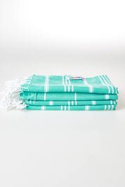 A model wearing size OneSize of the Hammamas Cotton Bubs Towel in colour Spearmint (Green), from the front, showing the whole outfit