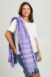 Model Monique wearing the Hammamas Original Cotton Towel in colour Iris (Purple), from the front, showing the whole outfit