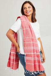 Model Monique wearing the Hammamas Original Cotton Towel in colour Flame (Red), from the front, cropped image