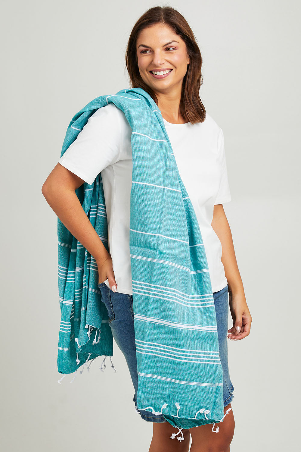 Model Monique wearing size OneSize of the Hammamas Original Towel in colour Emerald (Green), from the front, cropped image