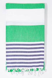 A model wearing the Hammamas Reef Cotton Towel in colour NavyApple (Green), from the front, showing the whole outfit
