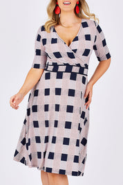 Model Jess wearing size 14 of the Faux Jersey Wrap in colour Checkers (White), from the front, cropped image