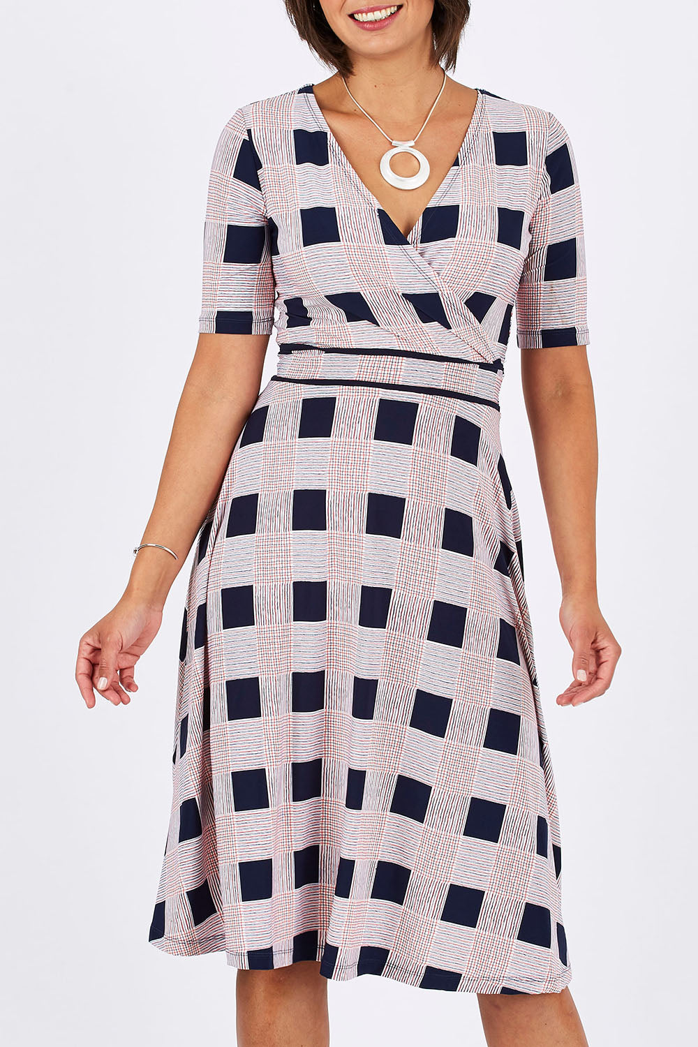 Model Thais wearing size 10 of the Faux Jersey Wrap in colour Checkers (White), from the front, cropped image