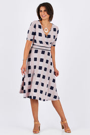 Model Thais wearing size 10 of the Faux Jersey Wrap in colour Checkers (White), from the front, showing the whole outfit