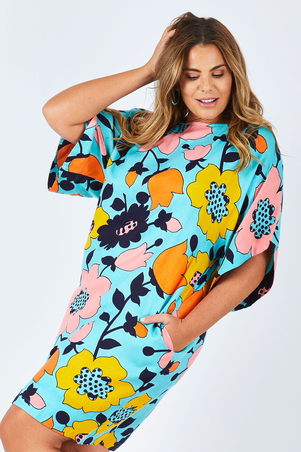 Model Fiona wearing size 16 of the Bell Sleeve Tunic Dress in colour Flower (Blue), from the front, cropped image
