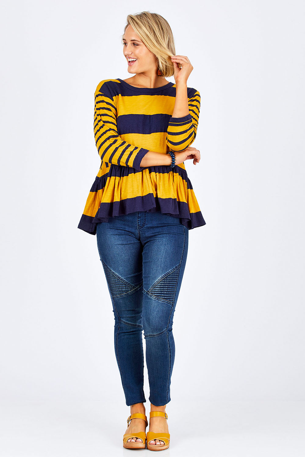 Model Emma wearing size 10 of the Hem Frill Stripe Top in colour SoFrilled (Blue), from the front, showing the whole outfit