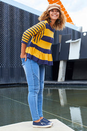 Model Summer wearing size 10 of the Hem Frill Stripe Top in colour SoFrilled (Blue), from the front, showing the whole outfit