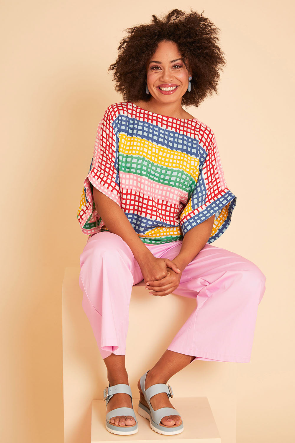 Model Olivia wearing size 10 of the Tie Back Bell Sleeve Top in colour Hopscotch (Pink), from the front, showing the whole outfit