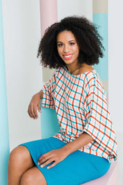 Model Schanez wearing size 10 of the Tie Back Bell Sleeve Top in colour Check (White), from the front, showing the whole outfit