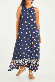 Model Noli wearing size 14 of the Falling Bricks Maxi in colour Jigsaw (Blue), from the front, cropped image