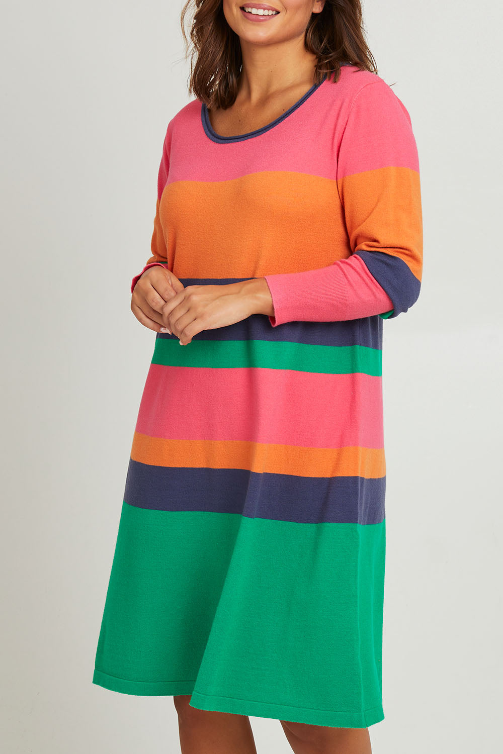 Model Monique wearing size L of the Knit Stripe Dress in colour Multihues (Pink), from the front, cropped image