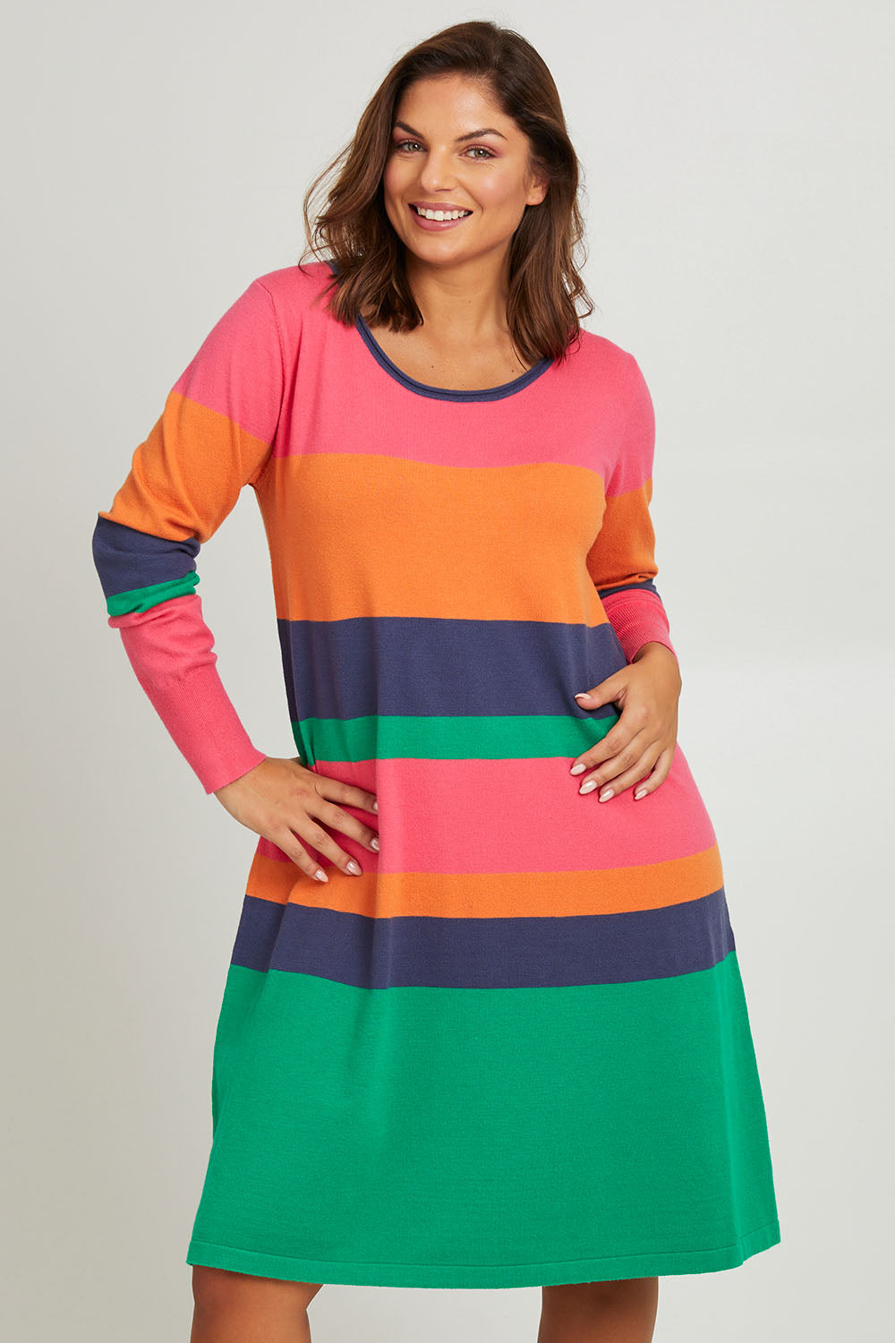 Model Monique wearing size L of the Knit Stripe Dress in colour Multihues (Pink), from the front, cropped image