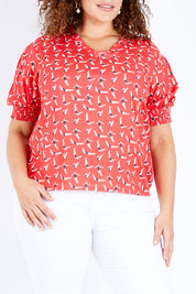 Model Jess wearing size 16 of the Printed V Neck Top in colour Diving (Pink), from the front, cropped image