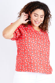 Model Jess wearing size 16 of the Printed V Neck Top in colour Diving (Pink), from the front, cropped image