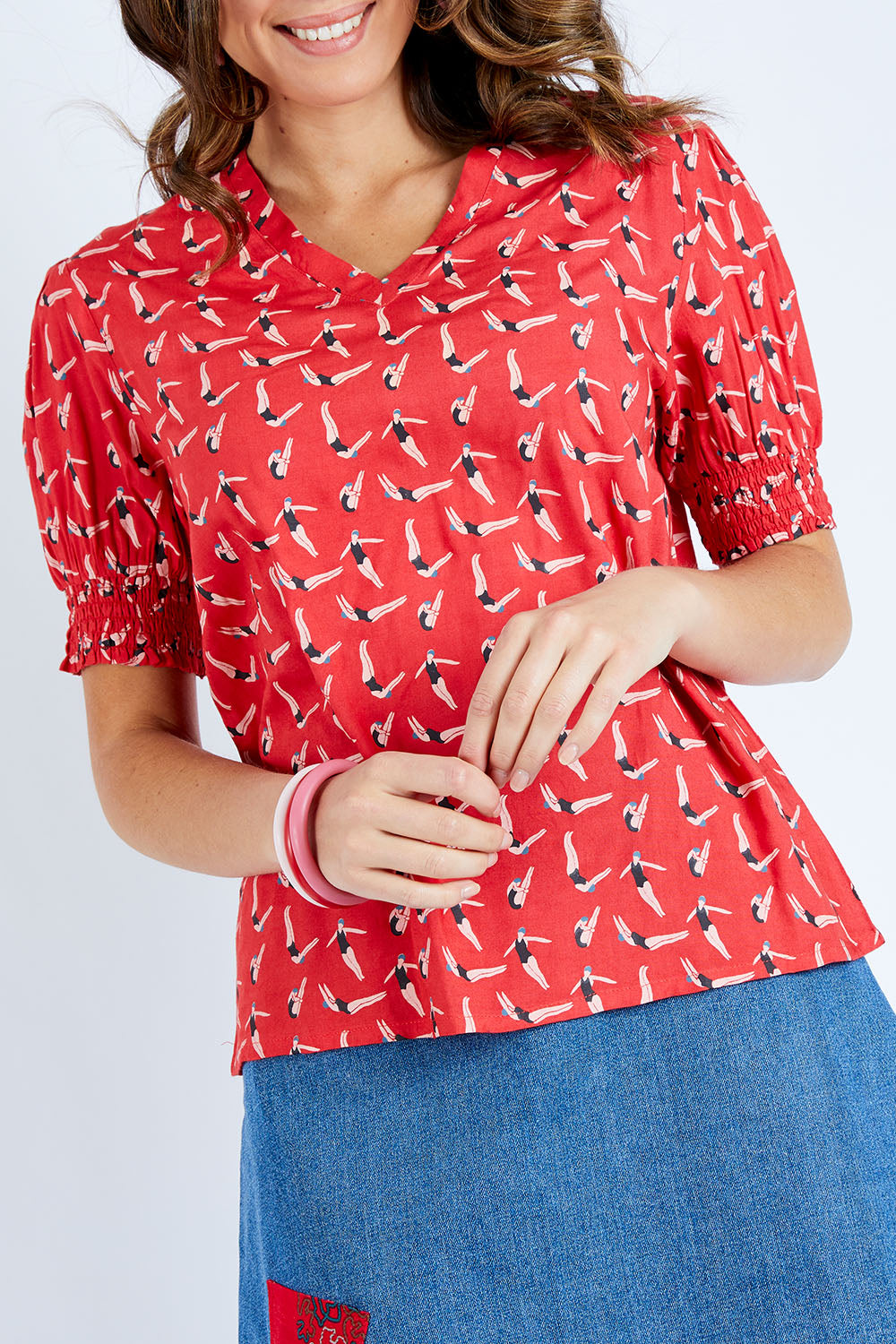 Model Madeline wearing size 10 of the Printed V Neck Top in colour Diving (Pink), from the front, cropped image
