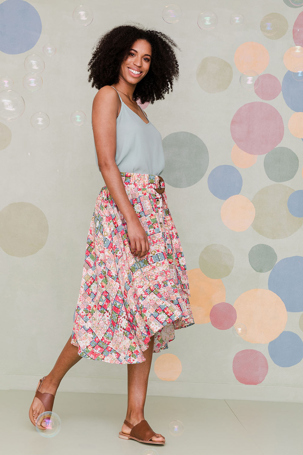 Model Schanez wearing size 10 of the Belted Button Skirt in colour Patchmeup (Pink), from the front, showing the whole outfit