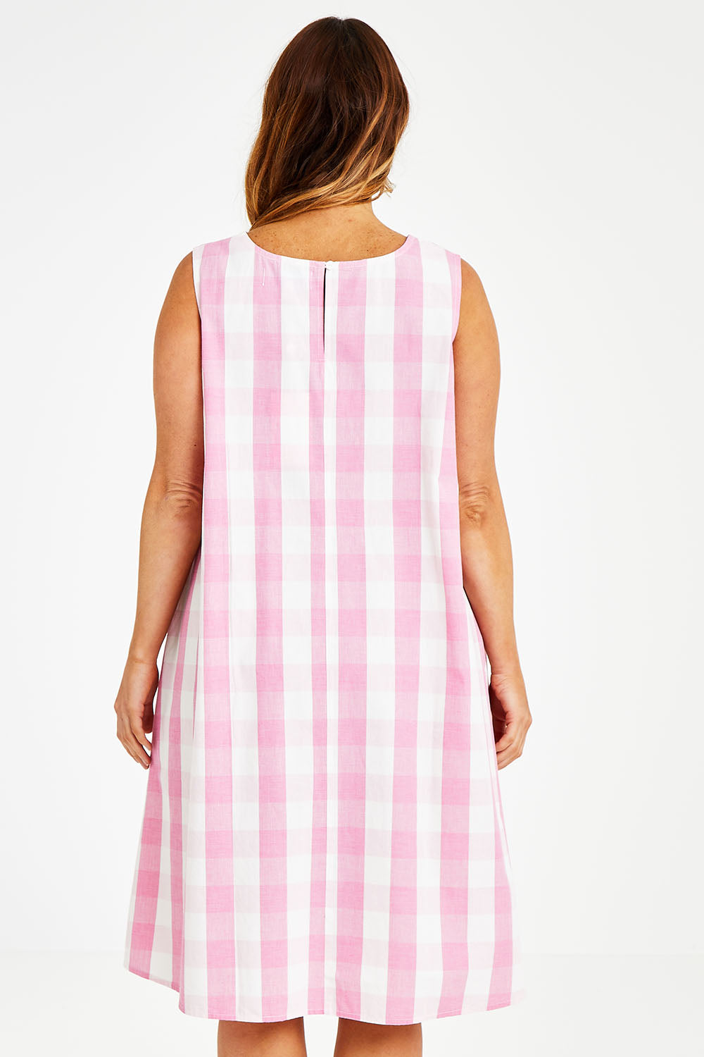 Model Laura wearing size 14 of the Gingham Swing Dress in colour Gingham (Pink), from the back