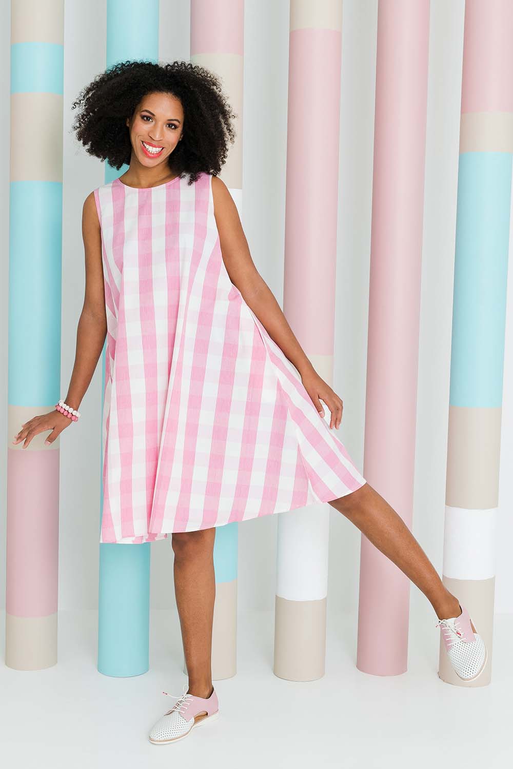Model Schanez wearing size 10 of the Gingham Swing Dress in colour Gingham (Pink), from the front, showing the whole outfit