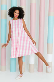 Model Schanez wearing size 10 of the Gingham Swing Dress in colour Gingham (Pink), from the front, showing the whole outfit