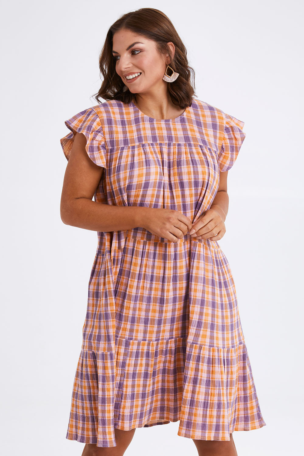 Model Monique wearing size 14 of the Ruffle Sleeve Tier Dress in colour Mixedcheck (Pink), from the front, cropped image