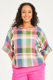 Model Noli wearing size 14 of the Bell Sleeve Top in colour Check (Blue), from the front, cropped image