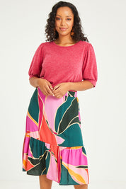 Model Noli wearing size 14 of the Flitter Skirt in colour Geo (Pink), from the front, cropped image