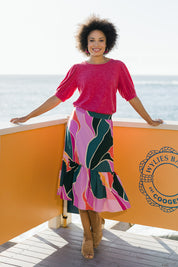 Model Olivia wearing size 10 of the Flitter Skirt in colour Geo (Pink), from the front, showing the whole outfit
