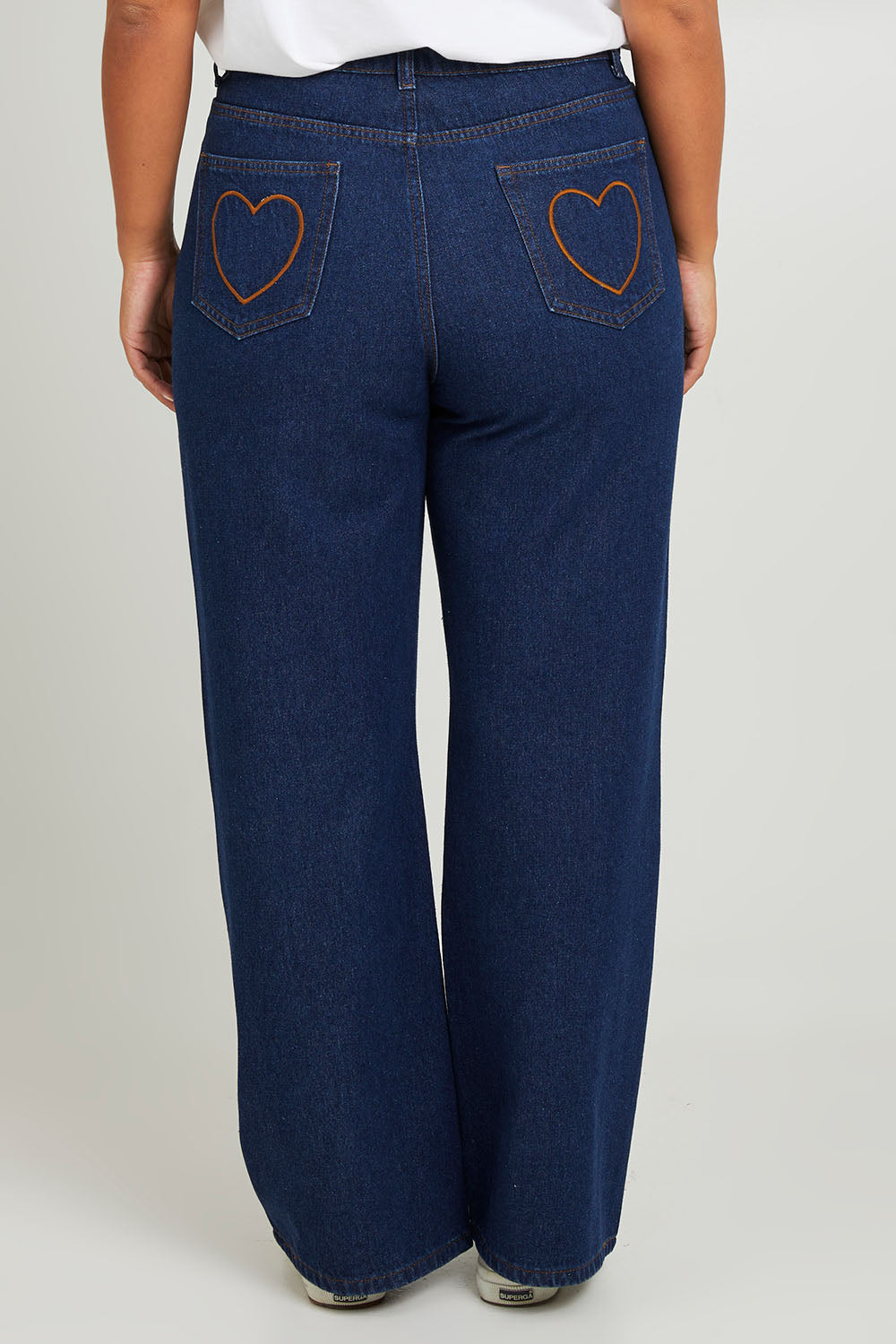 Model Monique wearing size 14 of the Patch Denim High Waist Jeans in colour Heart (Blue), from the back