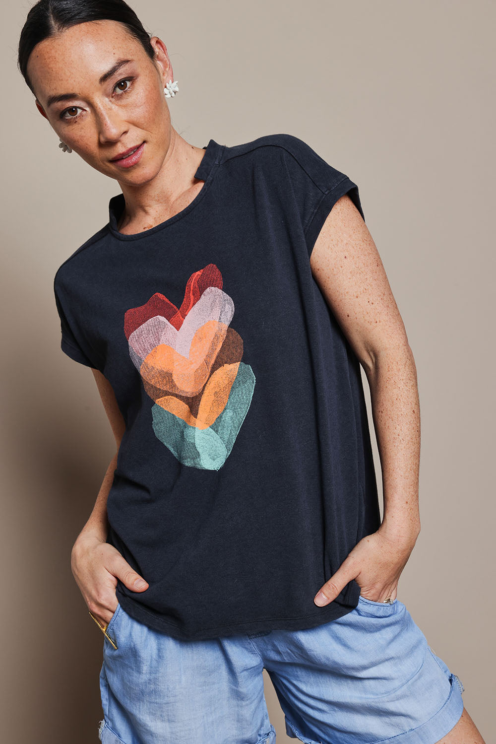 Model Katie wearing size 10 of the Heart Logo Tee in colour Orgheart, from the front, cropped image