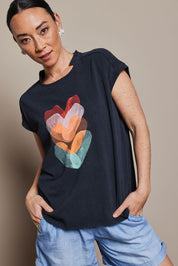 Model Katie wearing size 10 of the Heart Logo Tee in colour Orgheart, from the front, cropped image