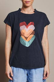 Model Katie wearing size 10 of the Heart Logo Tee in colour Orgheart, from the front, cropped image