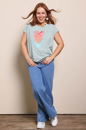 Model Georgiel wearing size 10 of the Heart Logo Tee – Tealred in colour Tealred, from the front