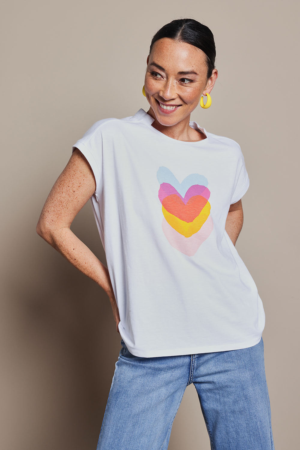 Model Katie wearing size 10 of the Heart Logo Tee in colour Yelloheart, from the front, cropped image