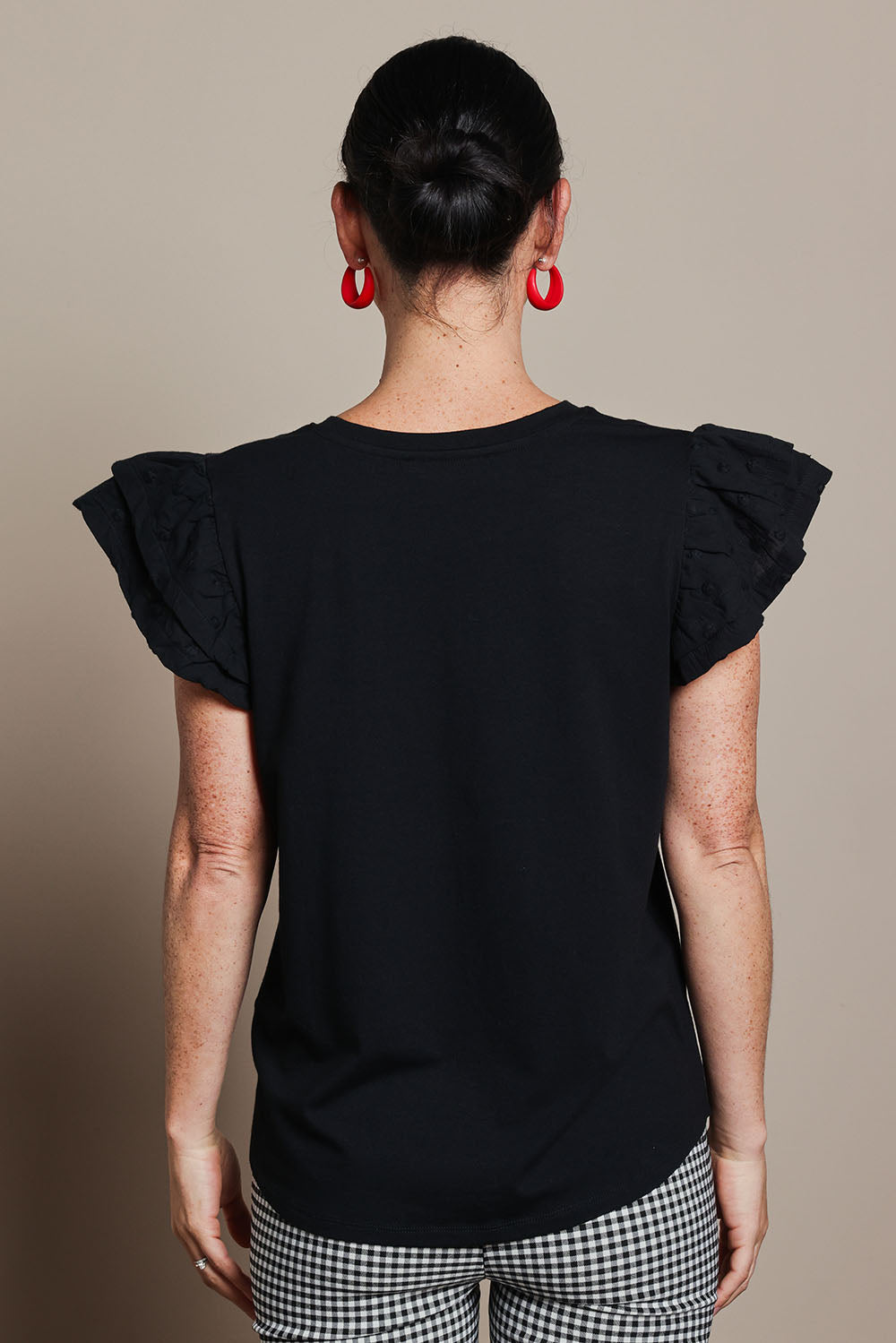 Model Katie wearing size 10 of the Ruffle Sleeve Top in colour Black (Black), from the back