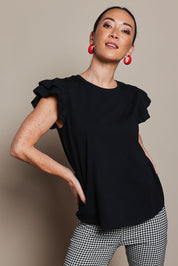 Model Katie wearing size 10 of the Ruffle Sleeve Top in colour Black (Black), from the front, cropped image