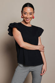 Model Katie wearing size 10 of the Ruffle Sleeve Top in colour Black (Black), from the front, cropped image